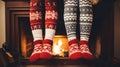 Girls standing in front of fireplace in winter sweaters wearing. Feet in wool socks near fireplace Royalty Free Stock Photo