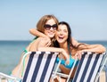 Girls sunbathing on the beach chairs Royalty Free Stock Photo