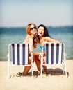 Girls sunbathing on the beach chairs Royalty Free Stock Photo