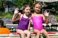 Girls in swimsuits waving hands while
