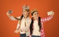 Girls taking selfie photo smartphone camera. Spoiled children concept. Egocentric princess. Kids wear golden crowns Royalty Free Stock Photo