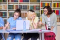 Girls teenage students studying in library with teacher mentor