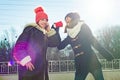 Girls teens shout into a megaphone paper cup, dressed in winter clothes, sunny winter day. Royalty Free Stock Photo