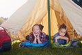 Girls only tent, no boys allowed. Two young girls lying on their sleeping bags in their tent. Royalty Free Stock Photo