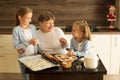 Girls with grandma are preparing Christmas cookies in the kitchen Royalty Free Stock Photo