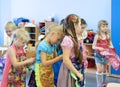 Girls tie aprons each other in kindergarten