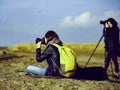 Girls tourist on a rock to photograph nature with camera on a mountain. Holiday Travel Concept.