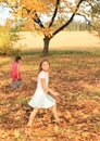 Girls walking barefoot in dead leaves