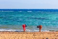 Girls wash their feet in the sea.