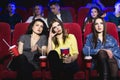 Girls watching a really boring movie at the cinema theater. Bad film. Royalty Free Stock Photo