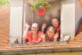 Girls waving hands, looking out the attic window Royalty Free Stock Photo