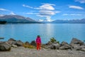 The girls stand looking at the nature of Lake Pukaki