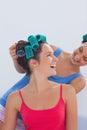 Girls wearing hair rollers sitting in bed Royalty Free Stock Photo