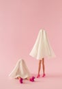 Girls in white ghost costume with rollers and high heels on pink background. Royalty Free Stock Photo