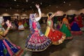 Girls and women are performing garba and dandiya dance wearing traditional Indian folk dress during Navratri festival in Calgary