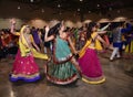 Girls and women are performing garba and dandiya dance wearing traditional Indian folk dress during Navratri festival in Calgary