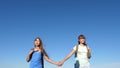 Girls, women travelers go holding hands on a background of blue sky. close-up. teamwork tourists teenagers. Women Royalty Free Stock Photo