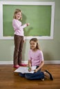 Girls writing on blackboard and doing homework Royalty Free Stock Photo