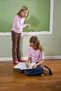 Girls writing on blackboard and doing homework Royalty Free Stock Photo