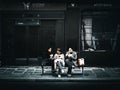 Girls' friends sit down for lunch on a wooden bench on the sidewalk in the streets of Paris