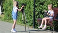 Children with photo appart in a city park.