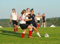 Girls youth soccer players compete for the ball.