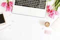 Top view of female worker desktop with laptop, flowers and different office supplies items. Feminine creative design workspace. Royalty Free Stock Photo