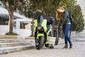 Girona, Spain, October 25, 2022. Woman removing the battery from a Silence Electric motorcycle