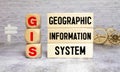 GIS - Geographic Information System write on a book isolated on Wooden Table.