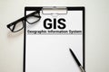 GIS - Geographic Information System write on a book isolated on Wooden Table