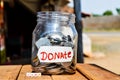 give donate,donate money in jar and out side written text of give,wooden table on give donate