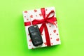 Give gift car key concept top view. Present box with red ribbon bow, heart and car key on green colored background Royalty Free Stock Photo