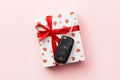 Give gift car key concept top view. Present box with red ribbon bow, heart and car key on pink colored background Royalty Free Stock Photo