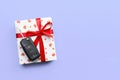 Give gift car key concept top view. Present box with red ribbon bow, heart and car key on purple colored background Royalty Free Stock Photo