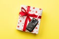 Give gift car key concept top view. Present box with red ribbon bow, heart and car key on yellow colored background Royalty Free Stock Photo