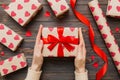 Give a gift on Valentine Day.Valentine gift. Beauty Woman hands holding Gift box with red bow over holiday background Royalty Free Stock Photo