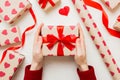 Give a gift on Valentine Day.Valentine gift. Beauty Woman hands holding Gift box with red bow over holiday background Royalty Free Stock Photo