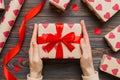 Give a gift on Valentine Day.Valentine gift. Beauty Woman hands holding Gift box with red bow over holiday background Royalty Free Stock Photo
