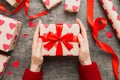 Give a gift on Valentine Day.Valentine gift. Beauty Woman hands holding Gift box with red bow over holiday background Royalty Free Stock Photo