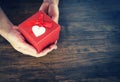 Give Love Man holding small red present box in hands with Heart for love Valentines day concept Royalty Free Stock Photo