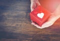 Give Love Man holding small red present box in hands with Heart for love Valentines day Giving a gift box with red ribbon Royalty Free Stock Photo