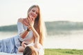 Give me high five. Photo of young mother and her daughter having good time on the green grass with lake at background