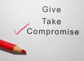 Give Take and Compromise text with red pencil check mark on paper Royalty Free Stock Photo