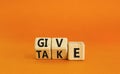 Give or take symbol. Concept word Give or Take on wooden cubes. Beautiful orange table orange background. Business give or take Royalty Free Stock Photo