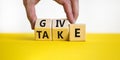 Give or take symbol. Concept word Give or Take on wooden cubes. Beautiful yellow table white background. Businessman hand. Royalty Free Stock Photo