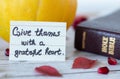 Give thanks with a grateful heart, a handwritten quote with Holy Bible Book and pumpkin. Royalty Free Stock Photo