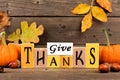 Give Thanks wood sign with pumpkins and leaves