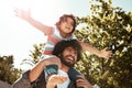 Give them the best childhood you can. a father giving his little son a piggyback ride outdoors. Royalty Free Stock Photo