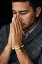 Give us this day our daily bread. Closeup shot of a young man praying with his eyes closed. Royalty Free Stock Photo