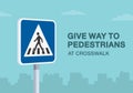 Give way to pedestrians at crosswalk road sign. Close-up view.